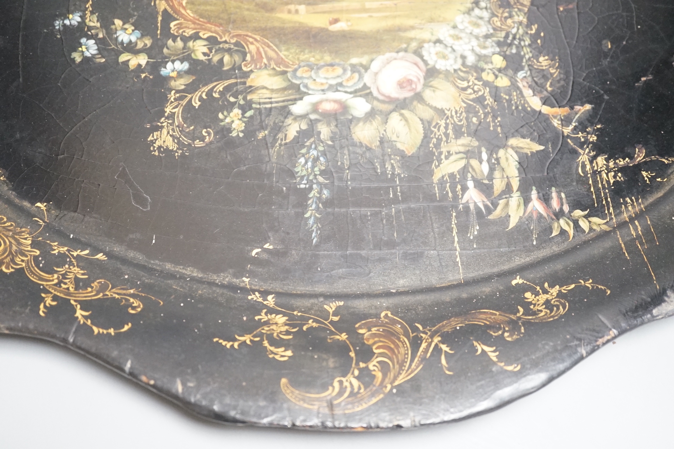 A Victorian papier mache tray, painted with ruins in a landscape - 64cm wide